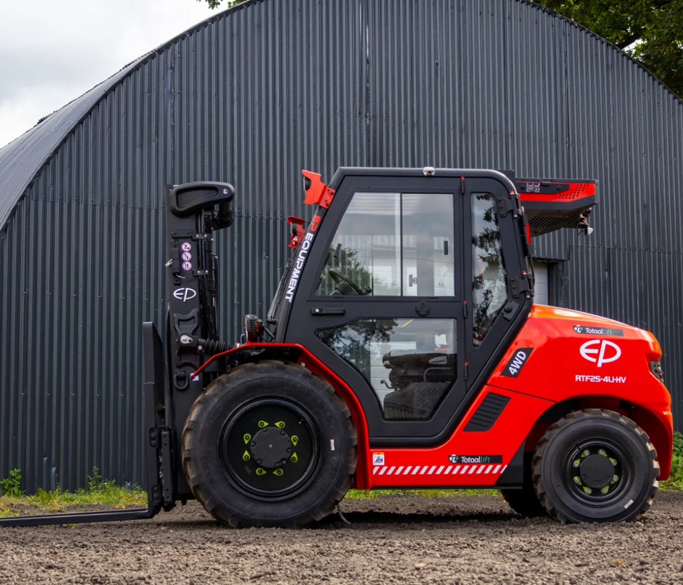 heftruck staat voor een loods op ruw terrein